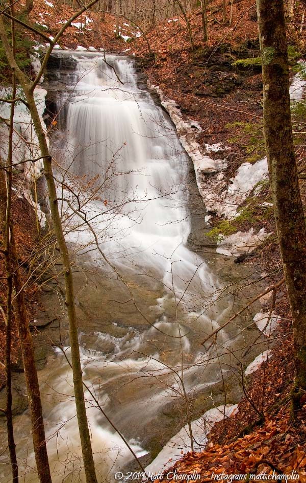 A fall view of Guppy Falls in moderate water flow. The stream turns 90 degrees just under the falls.