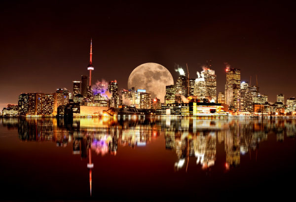 Poorly photoshopped image of a city and moon next to a body of water