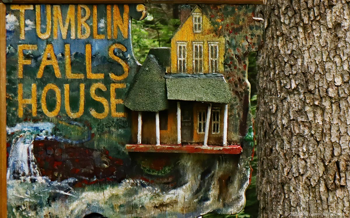 A unique 3D depiction of Tumblin' Falls house that hangs from a tree near the driveway.
