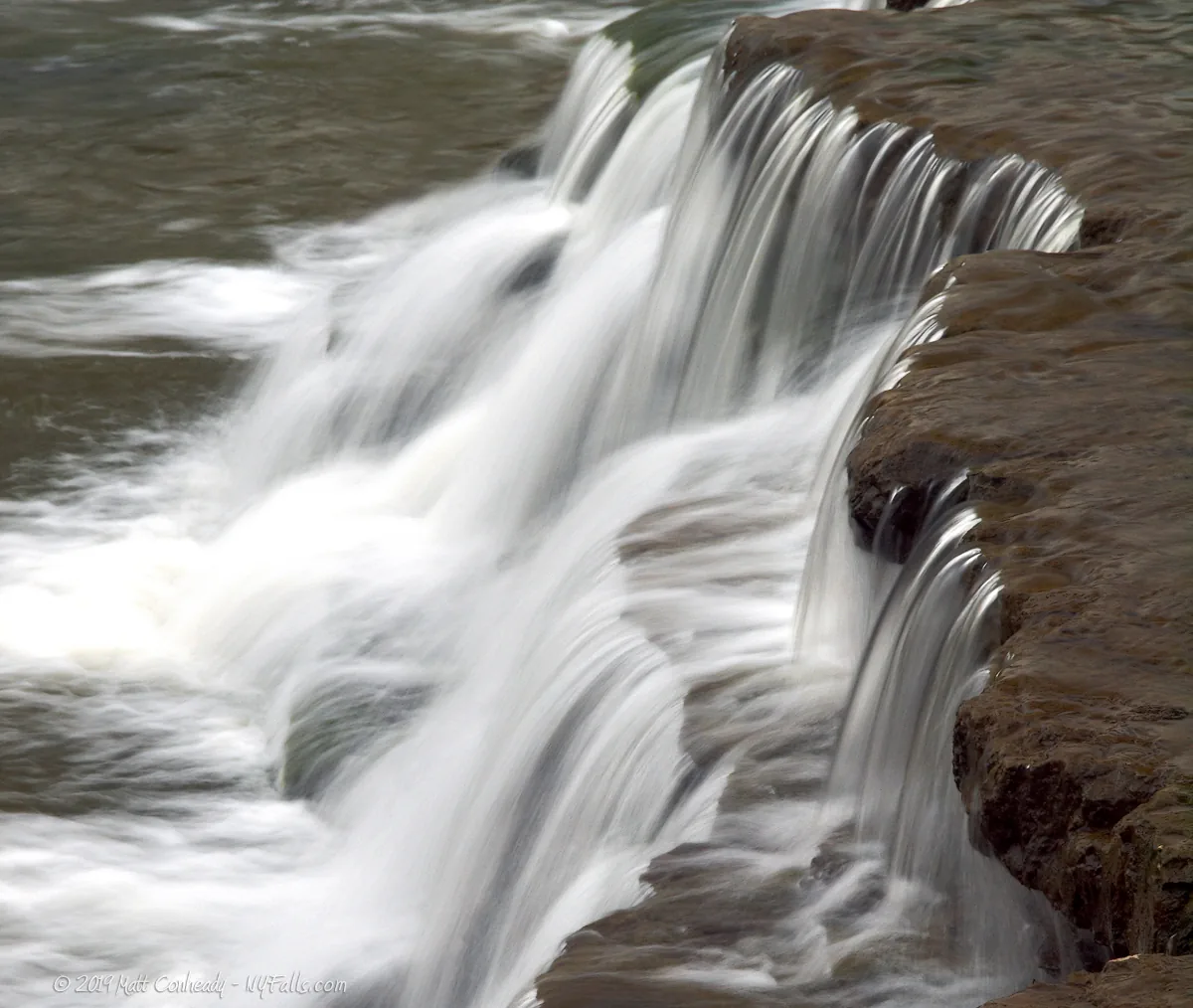 A closeup side view of LeRoy Falls and its irregular edge