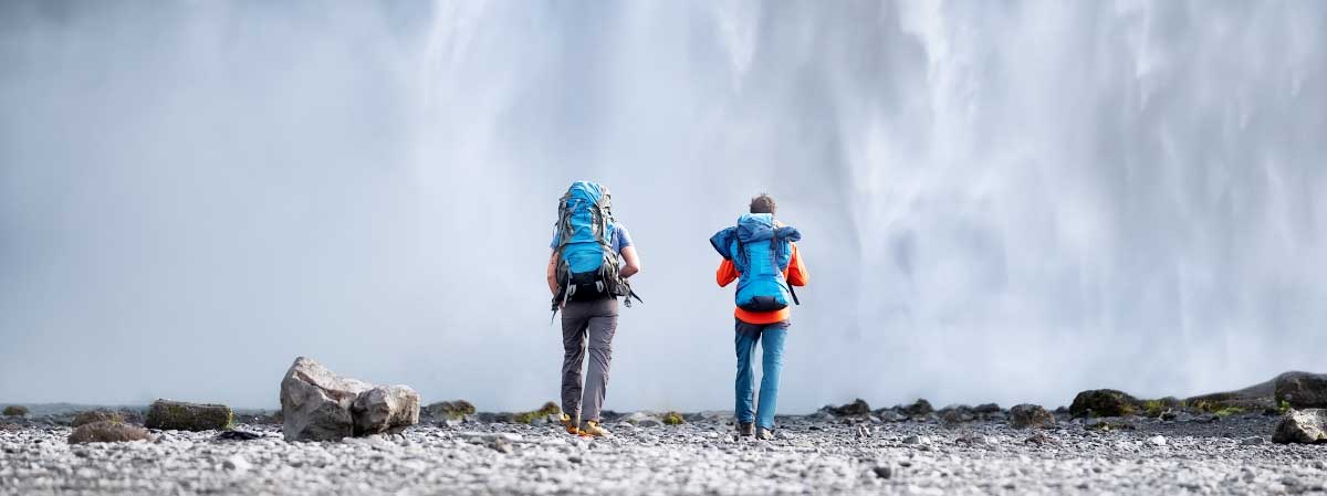 Two people hiking to a waterfall as part of mental health therapy