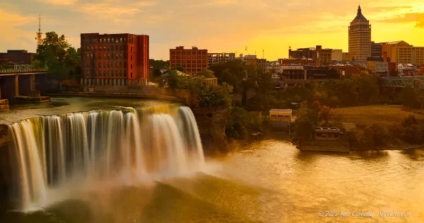 Rochester's High falls during sunset with the Kodak building and some of downtown Rochester visible.