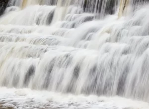 A closeup of the bottom, natural half of Honeoye Falls. The water bounces all over the place causing it to get frothy.