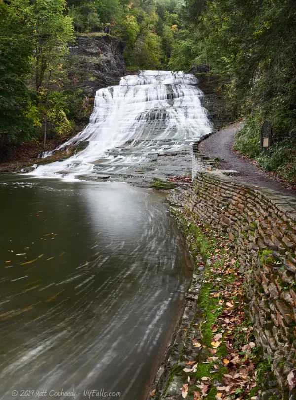 A view of Buttermilk Falls, the pool below, and the trail that leads into the gorge.