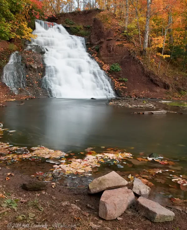 Holley Canal Falls, with the plunge pool and some stone in the foreground, in autumn