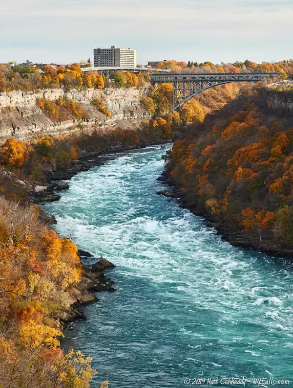 A view looking at the Niagara River and rapids with the Whirlpool Rapids Bridge in the background