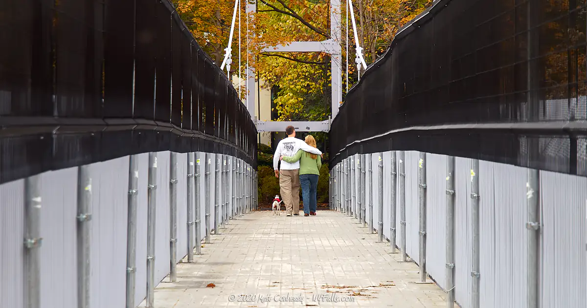 A couple walking across the suspension bridge over Fall Creek Gorge