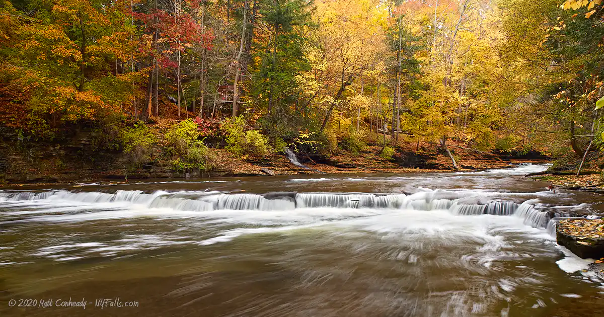 A small waterfall in a relatively flat section of Fall Creek Gorge in autumn.
