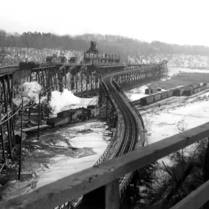 A vintage photo of the Genesee River Docks showing large train trestles leading to a rail line and shipyard.