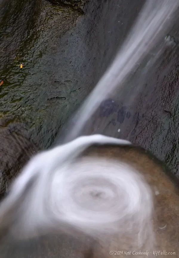 A small section of the Papermill waterfall that creates spiraling water in a small pool