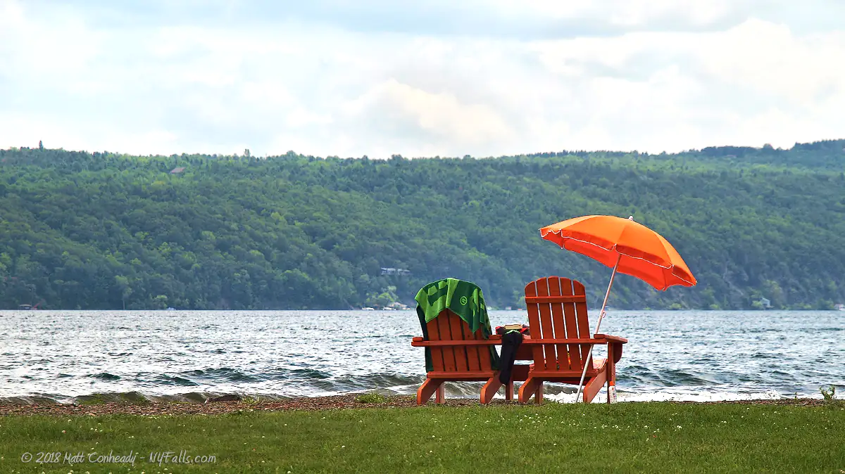 Adirondack Chairs and an umbrella along Canandaigua Lake at Onanda Park