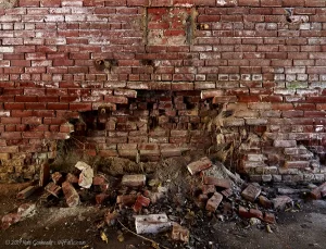 A partially collapsed brick wall inside one of the abandoned Baker Chemical Company buildings along the Keuka Outlet Trail