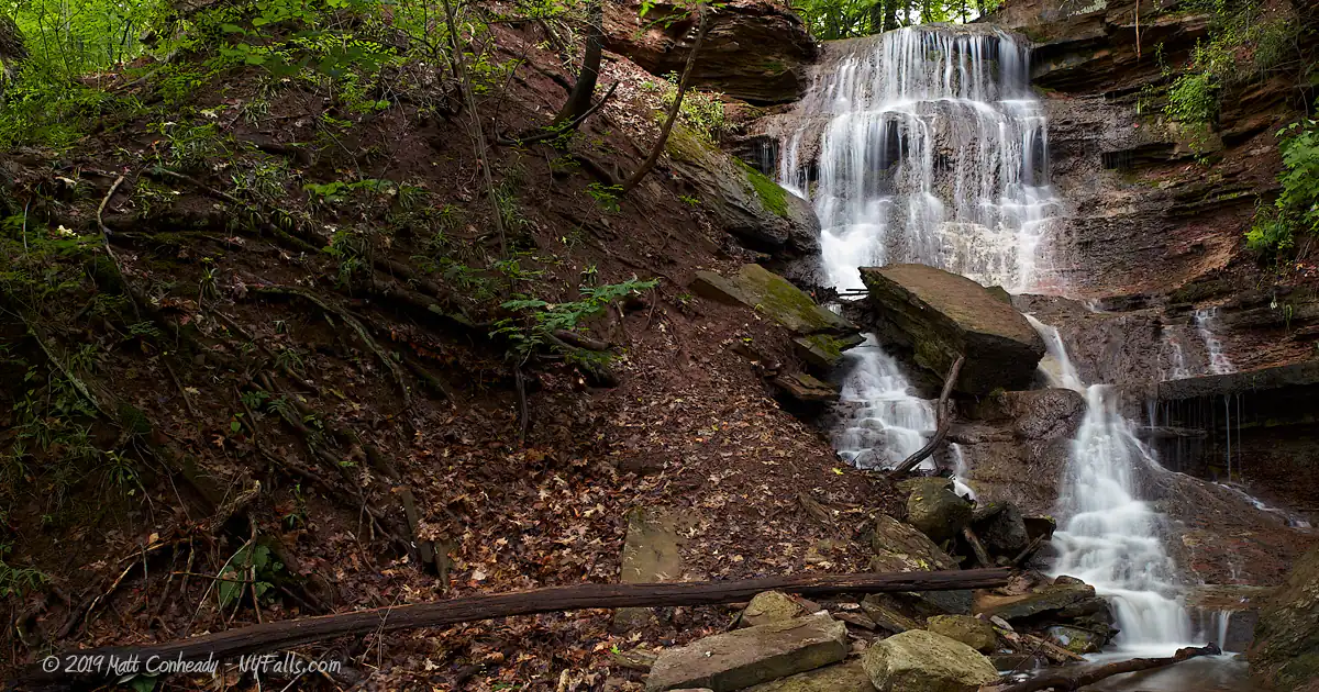 The Turning Point Park waterfall with a large fallen rock in the middle of it.
