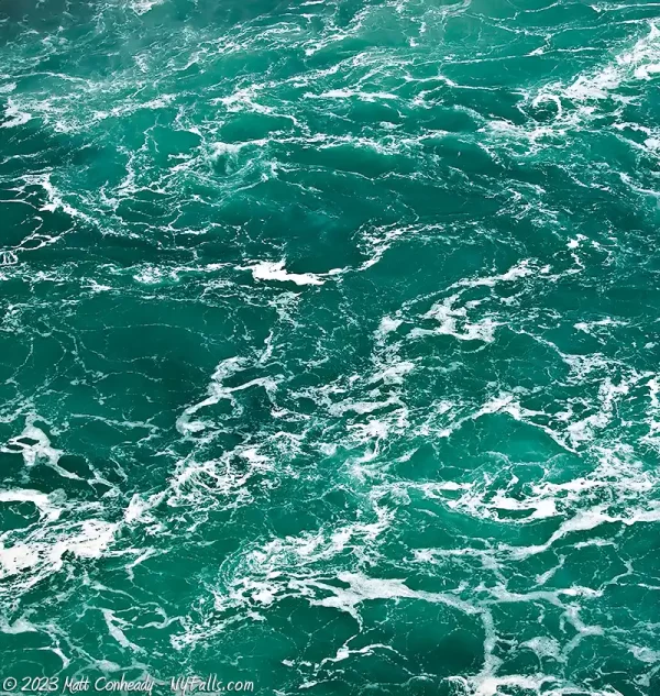 An accumulation of white foam in the water below Niagara Falls