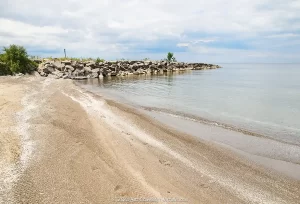 A break wall next to a sandy beak