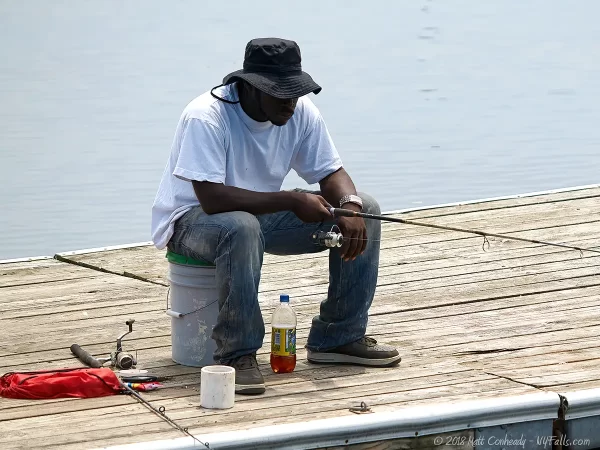 A man fishing on a dock at Seneca Lake