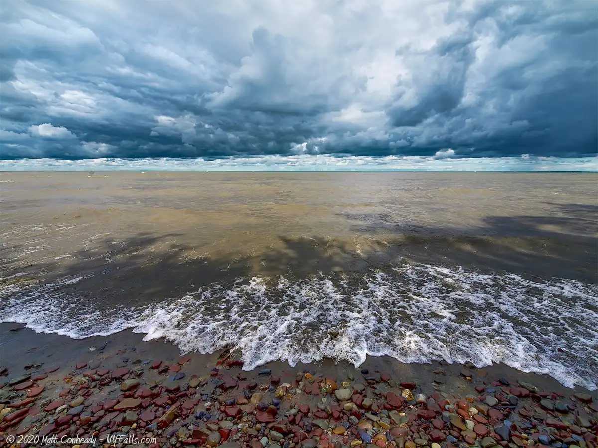 Dramatic clouds over Lake Ontario as a wave washed over the shoreline,