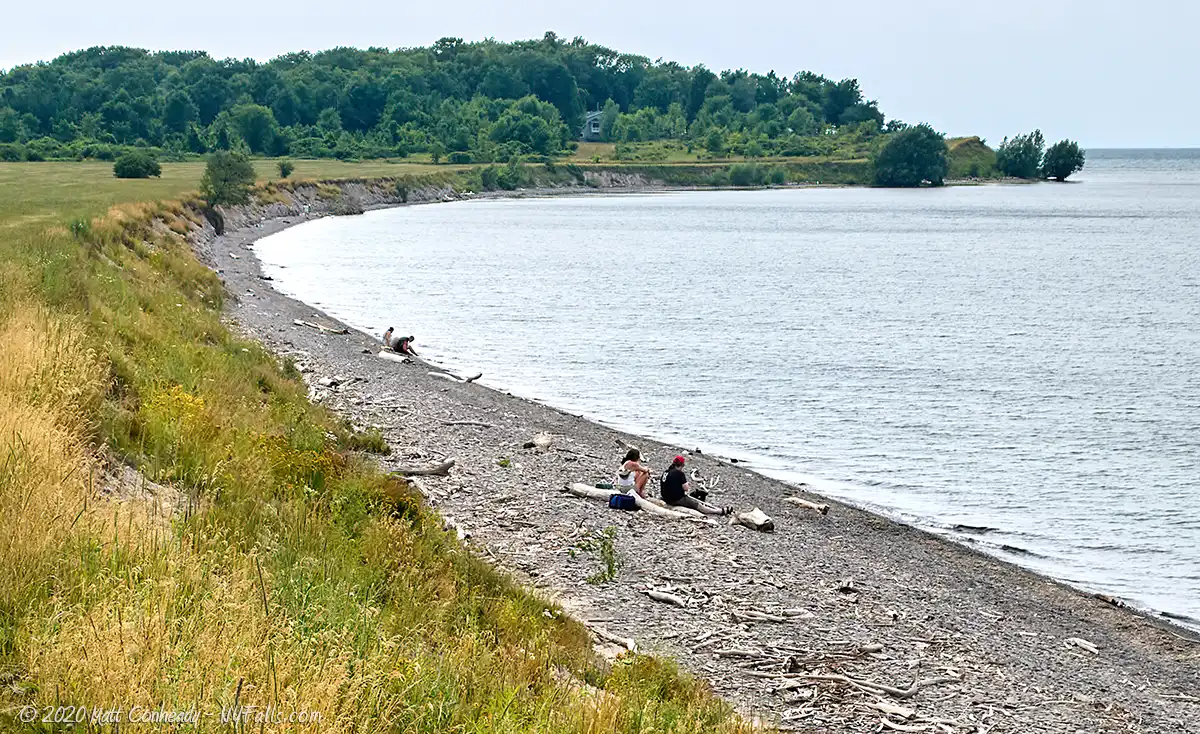 A couple sitting on the beach and enjoying the view of Lake Ontario at Lakeside Beach State Park.