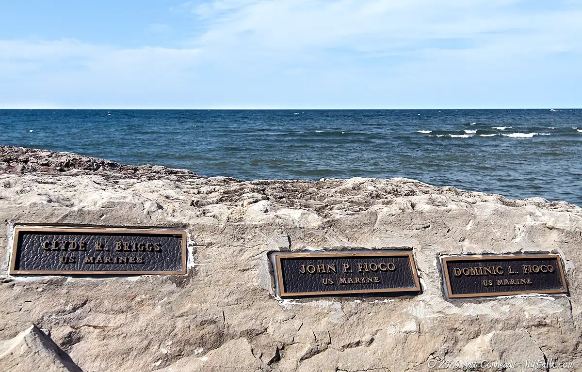 Veteran memorial plaques embedded in stones at Thompson Park on Lake Ontario.