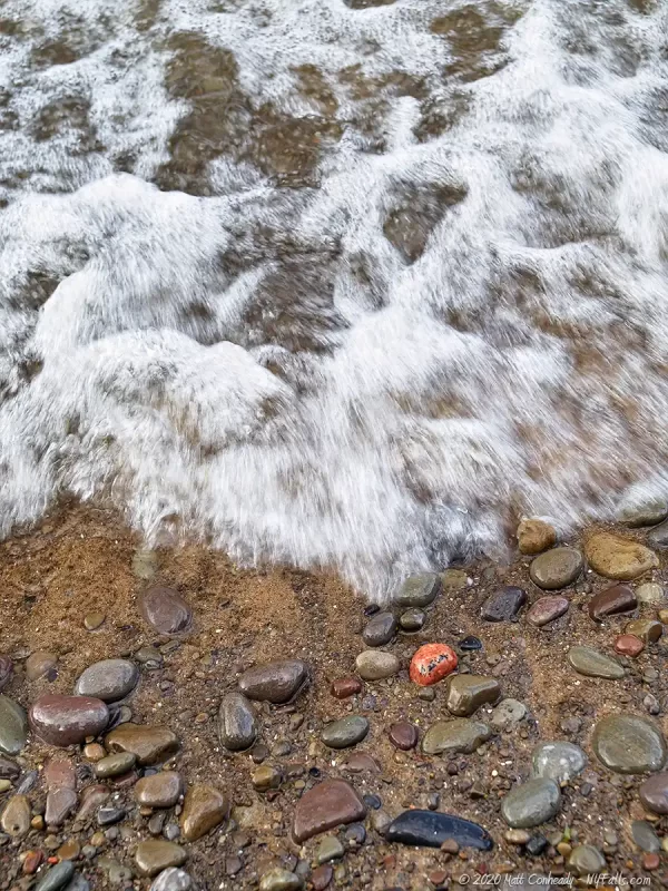 A waves crashing on the beach at Wilson-Tuscarora State Park