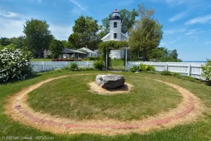 The foundation of the original Sodus Point lighthouse, with the replacement lighthouse in the background.