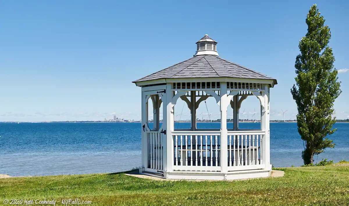 A gazebo in Hamburg Beach Town Park with a clear view of Lake Erie. The City of Buffalo is visible on the Horizon.
