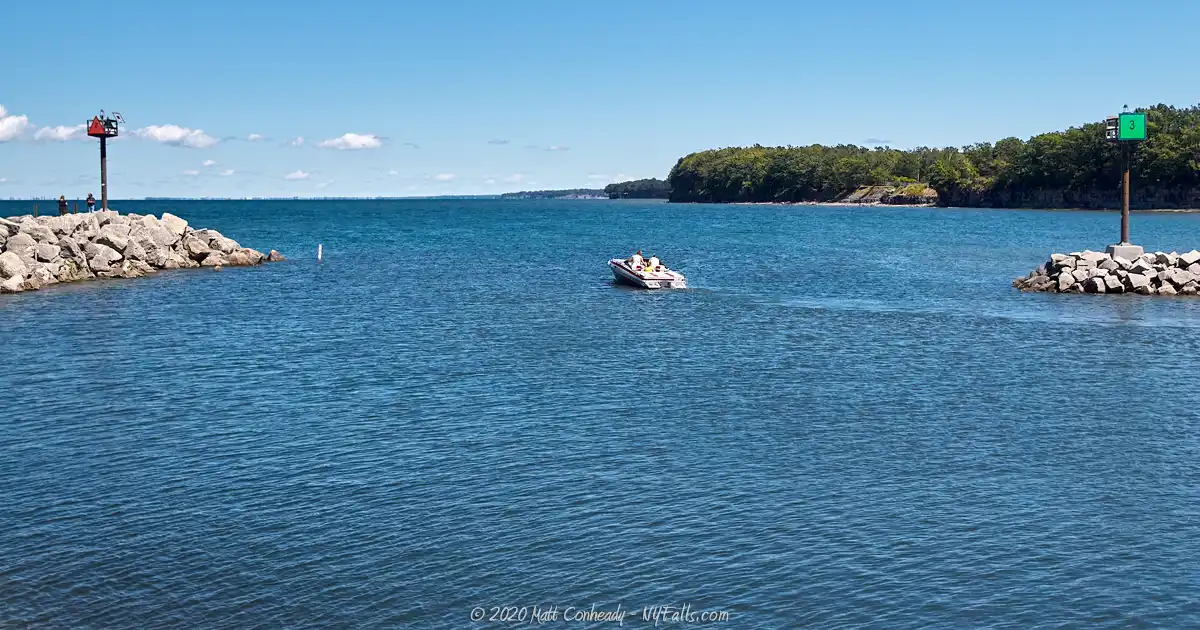 A small boat exiting Sturgeon Point Marina and setting off into Lake Erie.
