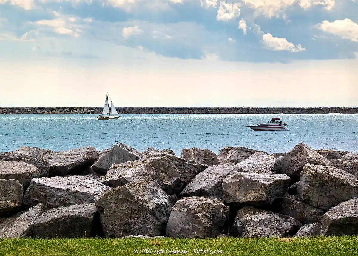 A motorboat passing a sailboat on Lake Erie at Buffalo Harbor State Park