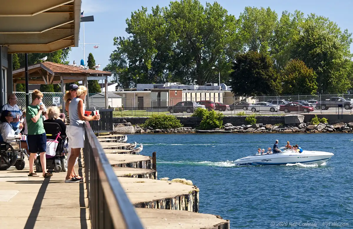 A boat goes from the Buffalo River into Lake Erie, as patrons of the Hatch restaurant look on