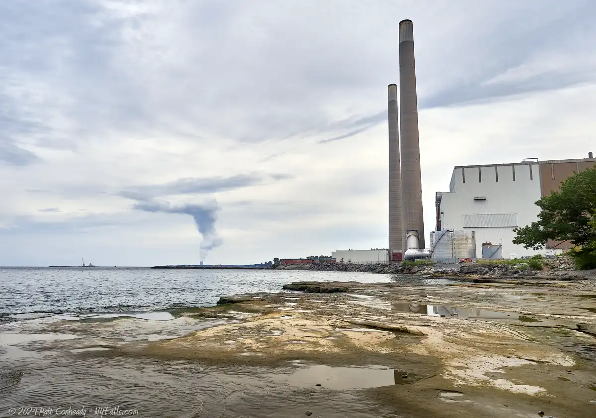 Flat rock in the foreground, Oswego Harbor oil power plant, with the Nine Mile Point Clean Energy Center off in the distance.